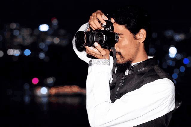 a man taking a picture with a camera that says nikon on it