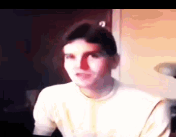 a man in a white shirt is looking at the camera