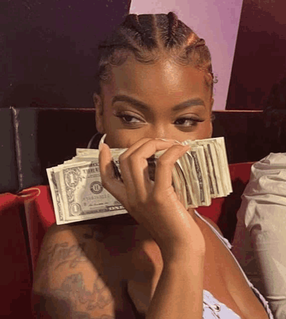 a woman holding a stack of one dollar bills