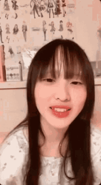 a girl with long hair and bangs is smiling for the camera