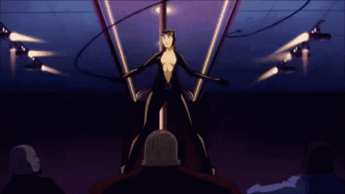 a woman in a black suit is dancing in front of a crowd of people