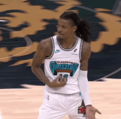 a man in a grizzlies jersey is dancing on a basketball court