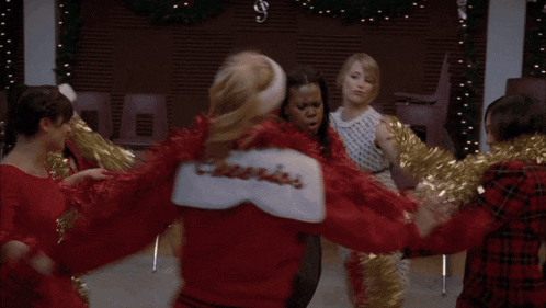 a group of cheerleaders wearing red and gold pom poms are dancing together