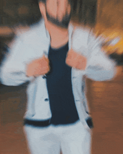 a blurry picture of a man in a white jacket and black shirt