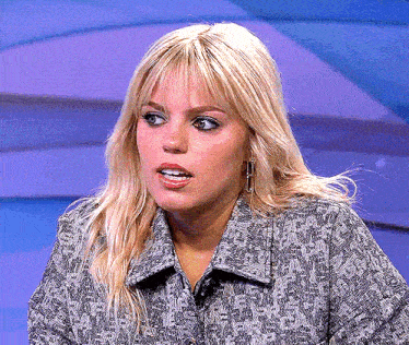 a close up of a woman 's face with a gray shirt on