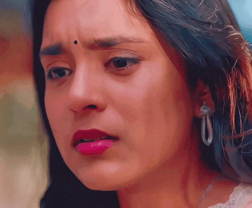 a close up of a woman 's face with pink lipstick and earrings