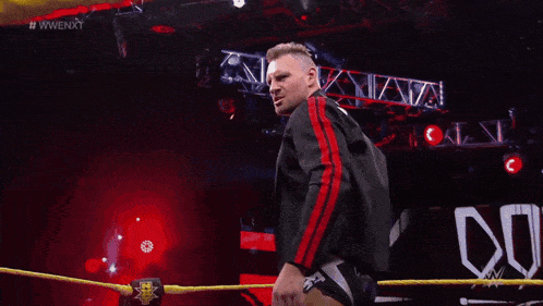 a man in a wrestling ring with the word dominik on his pants