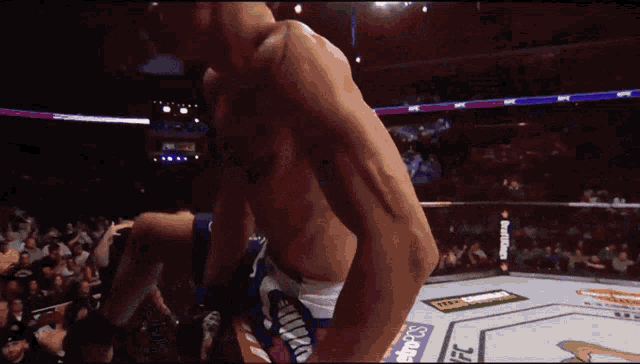 a man with a tattoo on his chest wears a pair of ufc gloves