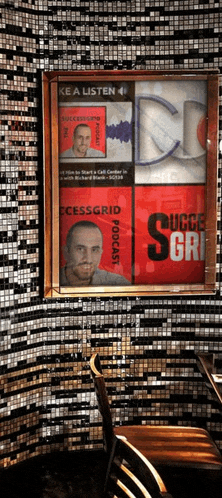 a framed poster for successgrid podcast hangs on a wall above a chair