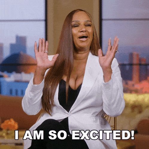 a woman says i am so excited while sitting on a couch