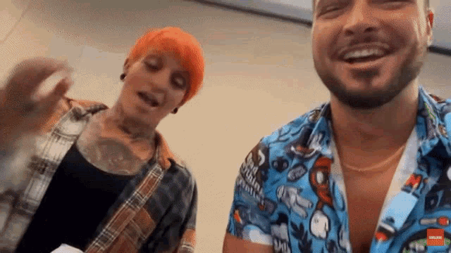 a man with a beard and a woman with red hair are laughing