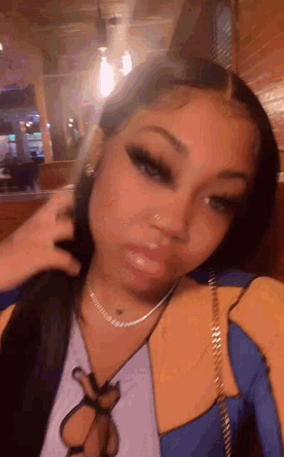 a woman wearing a necklace and earrings is taking a selfie .