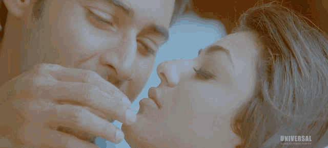 a man and a woman kissing in front of a universal entertainment logo