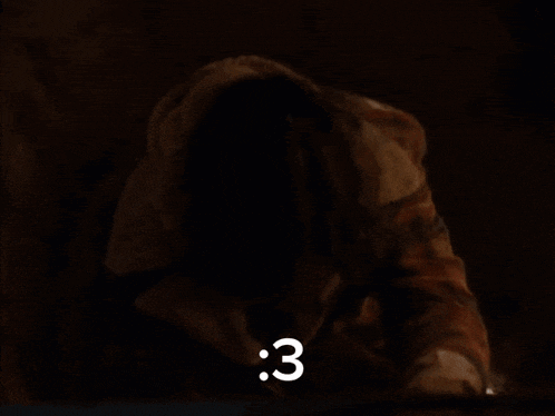 a person in a dark room with the number 3 in white letters