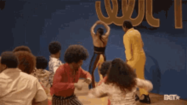a group of people are dancing in front of a bet logo