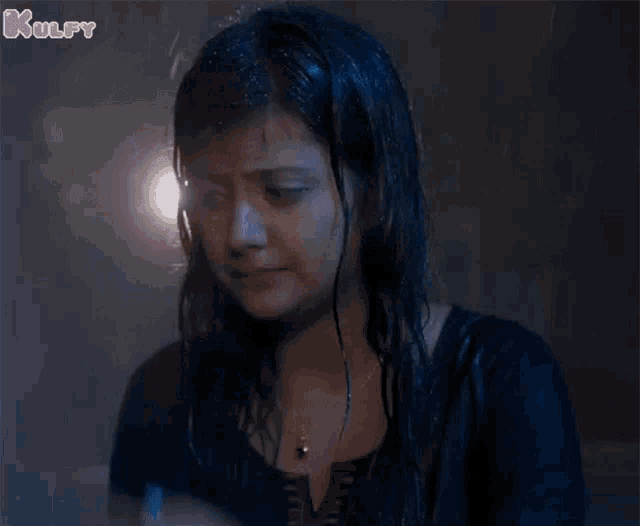 a woman with a watch on her wrist is crying in the rain .