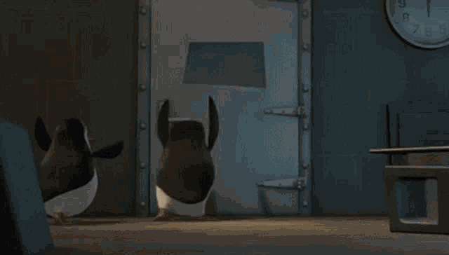 two penguins are jumping in a pile of popcorn in a room