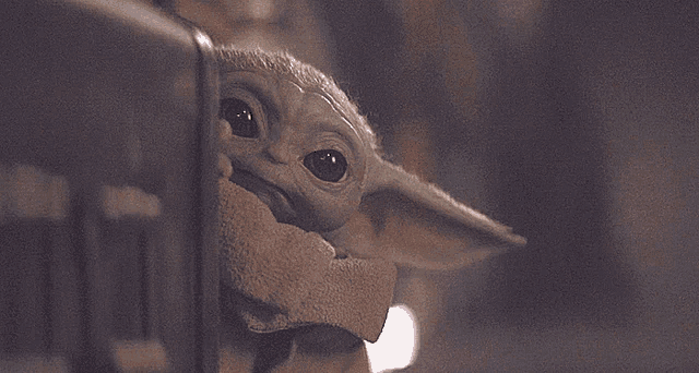 a close up of a baby yoda looking at the camera