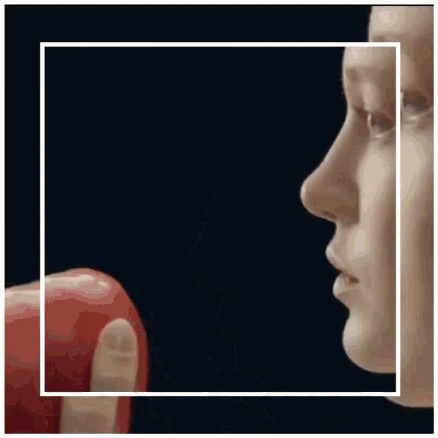 a woman is holding a red apple with a ring on her finger