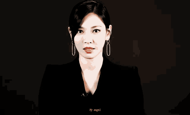 a woman wearing a black jacket and earrings says my angel