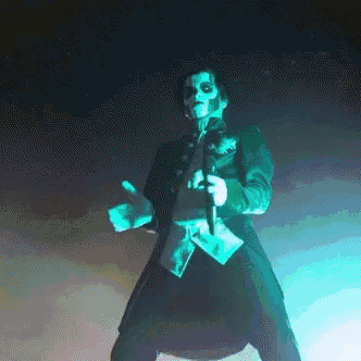 a man in a skeleton costume is holding a microphone and dancing on a stage .