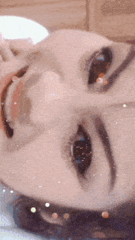 a close up of a woman 's face with sparkles on it