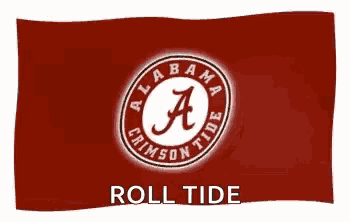 a red flag with the alabama crimson tide logo on it is waving in the wind .