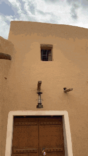 a building with a wooden door and a lantern on it
