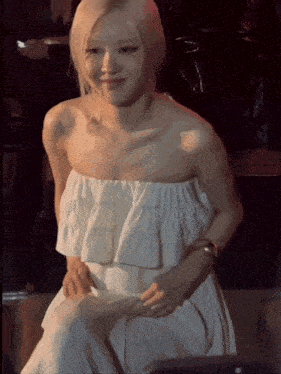 a woman in a white strapless dress is sitting down