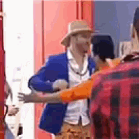 a man in a blue jacket and hat is hugging another man in a red and black plaid shirt .