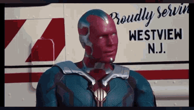 a man in a superhero costume stands in front of a westview n.j. ambulance