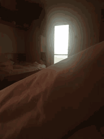 the sun is shining through the curtains of a dark room