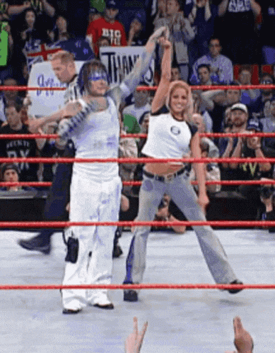 two wrestlers in a ring with one wearing a shirt that says big on it