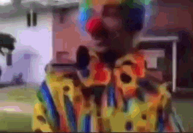 a blurry picture of a clown wearing a yellow and blue shirt
