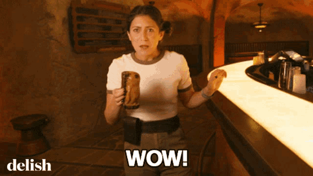 a woman holding a mug with wow written on the bottom