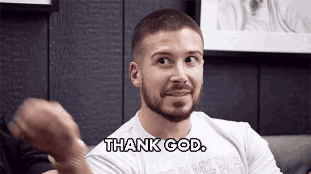 a man with a beard wearing a white shirt that says thank god