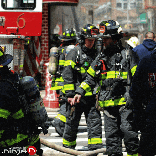a group of firefighters are standing in front of a fire truck numbered 6