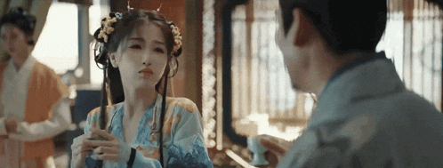 a man and a woman are talking to each other in a room .