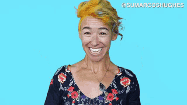 a woman with a floral shirt is crossing her fingers