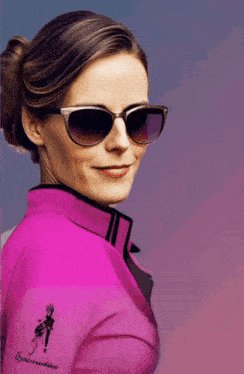 a woman wearing sunglasses and a pink shirt has a drawing of a woman on the sleeve