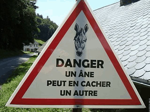 a sign that says danger on it with a donkey on it