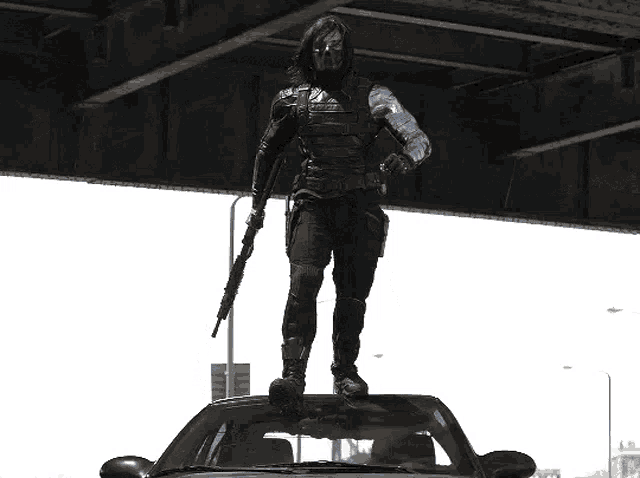a man standing on top of a car holding a rifle