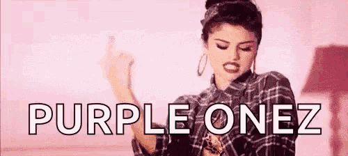 a woman in a plaid shirt is giving the middle finger and the words `` purple onez '' are above her .