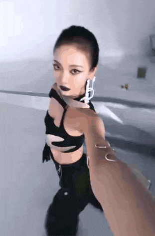 a woman in a black crop top and black pants is being held by a person .