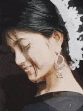 a woman with a flower in her hair and earrings