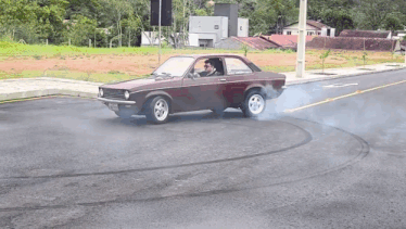 a man driving a car on a road with smoke coming out of it