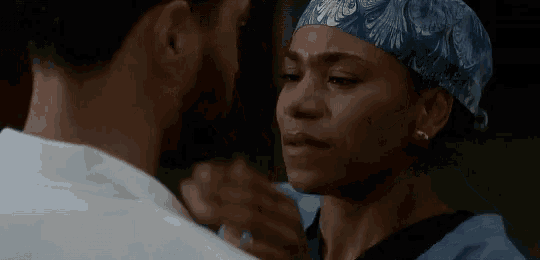 a man and a woman are kissing and the woman is wearing a scrub cap