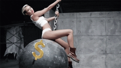 a woman is sitting on a large rock with a gold dollar sign on it