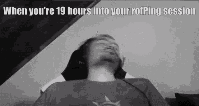 a black and white photo of a man laying on a couch with his head on a pillow .