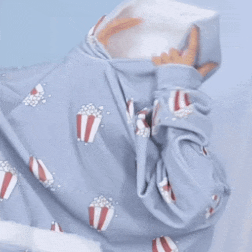 a man is wrapped in a blue blanket with popcorn on it